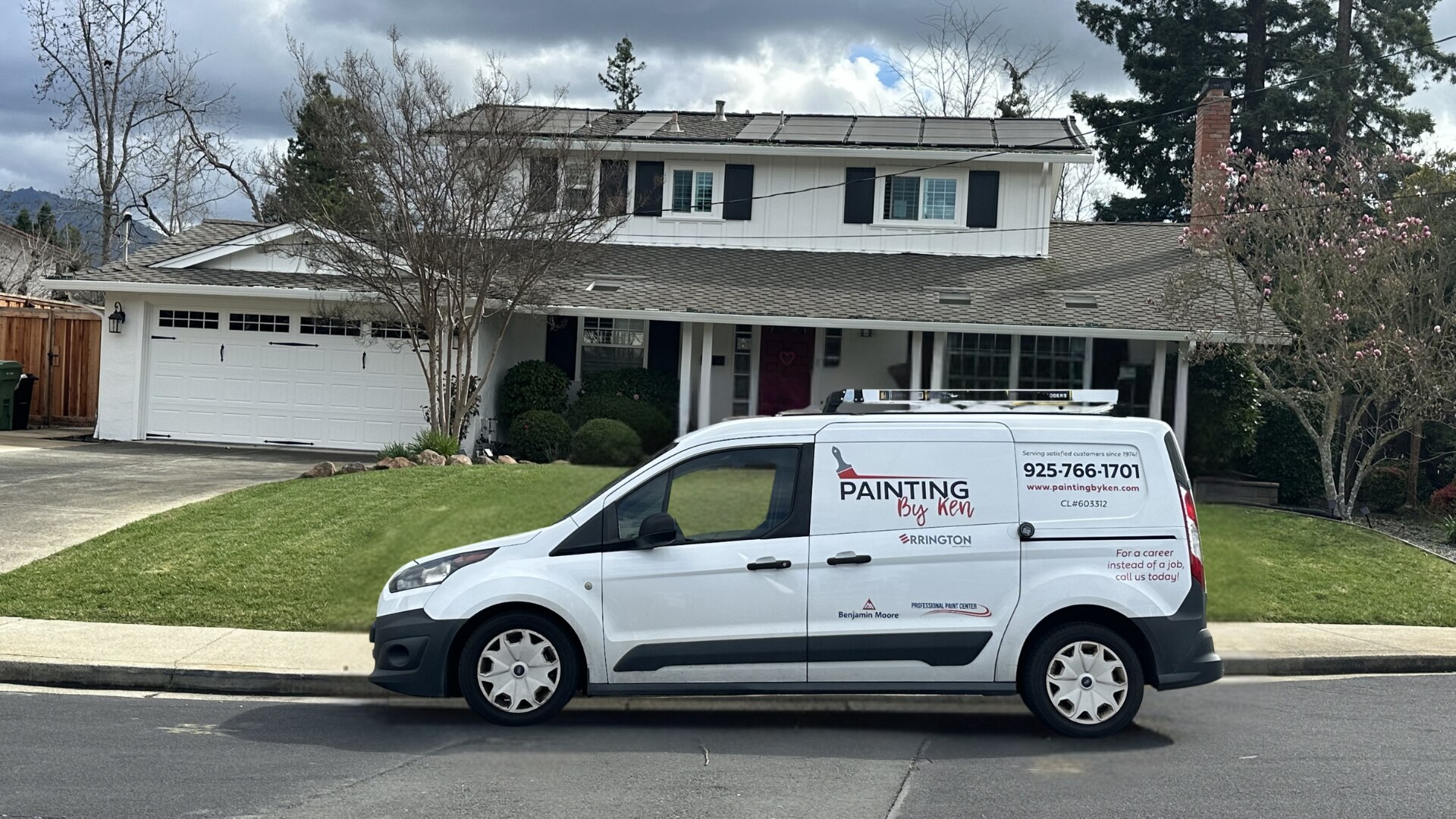 Painting By Ken van parked in front of a two-story home